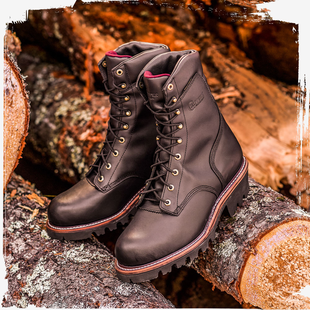 The Super Dna 9" Waterproof Steel Toe Insulated Logger in Black Oiled Leaning on pile of logs.
