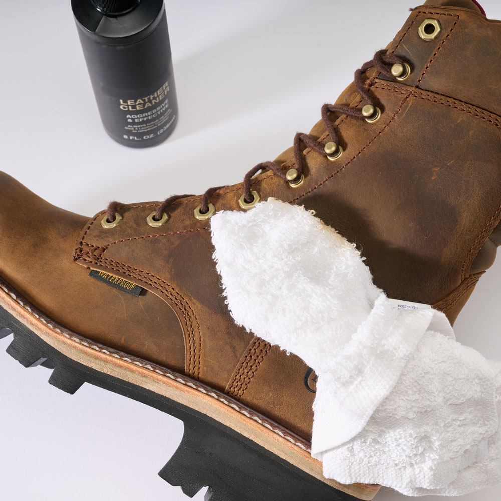 El Chippewa Super Dna 9" Logger, un pa&ntilde;o de limpieza y una botella de limpiador de cuero.