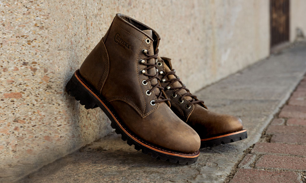 A pair of the Classic 2.0 6" Lace Up in Chocolate Apache propped on a concrete wall.
